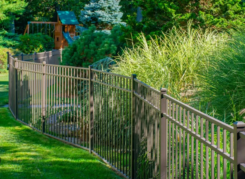 Bronze aluminum fence panel along a manicured yard