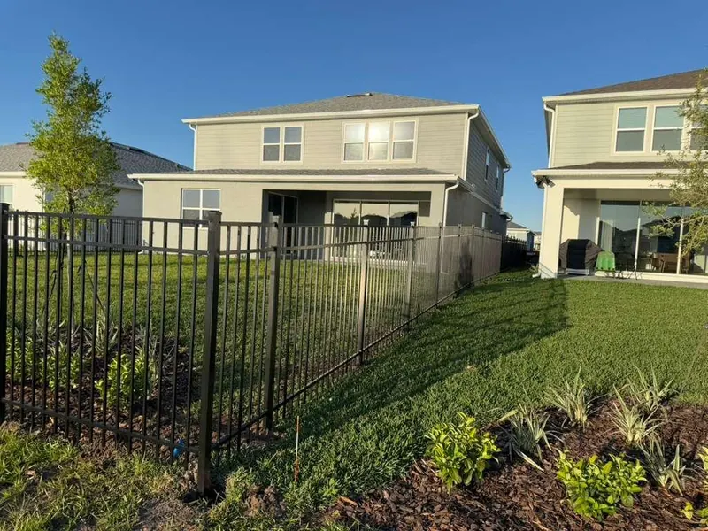 Black ornamental aluminum fence panel along a property line