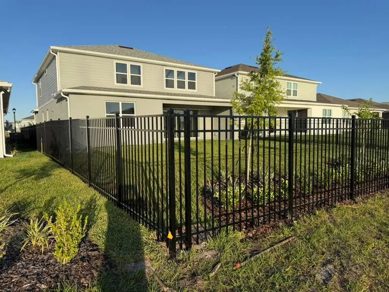Black ornamental aluminum fence with manicured landscaping