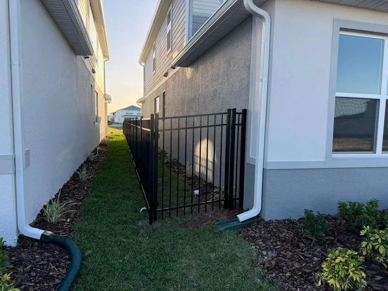 Black ornamental aluminum fence along a residential boundary