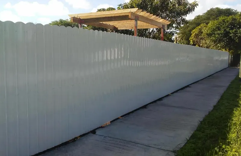 White aluminum privacy fence run along a backyard