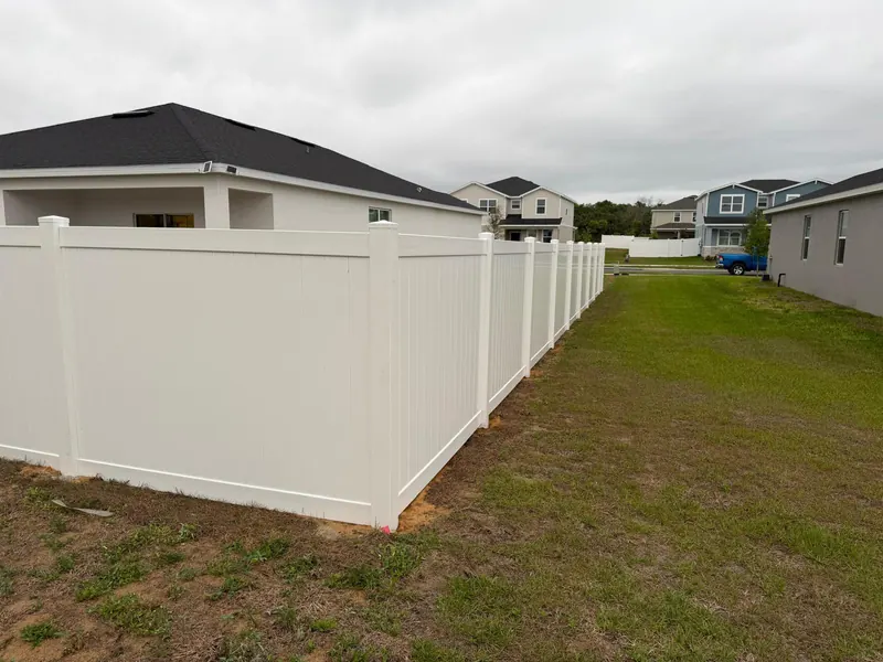 White vinyl privacy fence installed in a Florida backyard