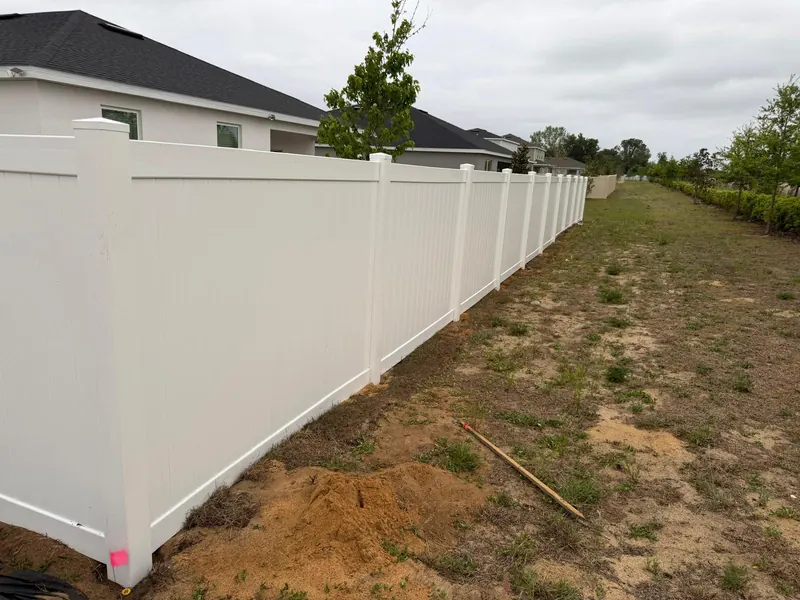 White vinyl privacy fence section along a property line