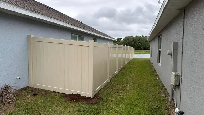 White vinyl privacy fence run along a Florida yard