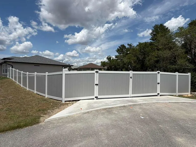 White vinyl privacy fence section beside a manicured lawn