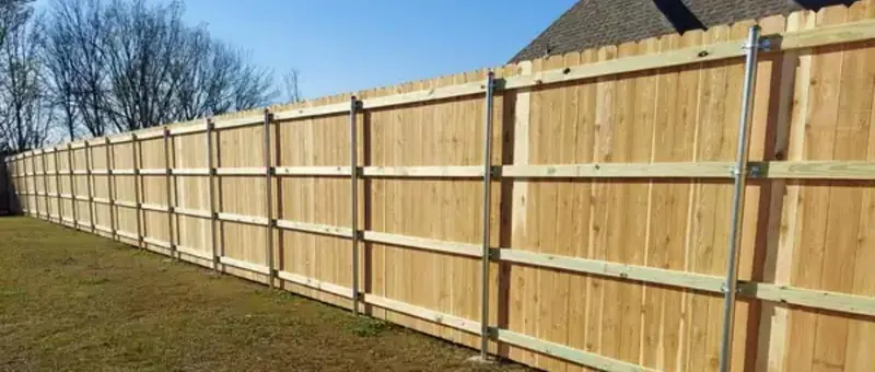 Wood fence next to a residential driveway